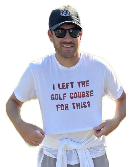 Coach Cory Asfeld at a meet, wearing a shirt reading I left the golf course for this