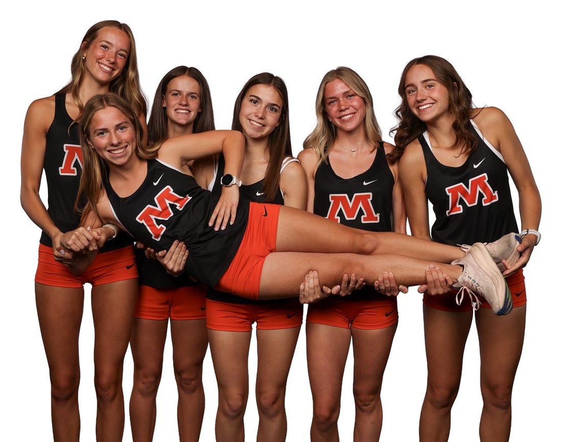 Six Moorhead girls holding a teammate horizontally across their arms
