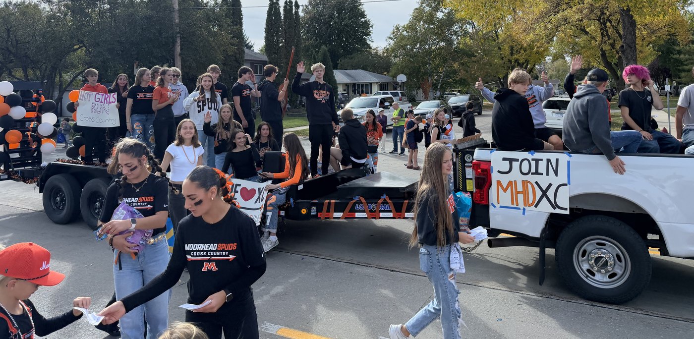 The Spuds cross country float at the Moorhead homecoming parade, with a Join MHD XC sign on the truck