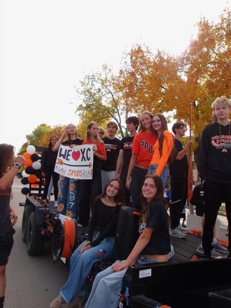 Moorhead cross country runners gathered on the float in orange and black with balloons